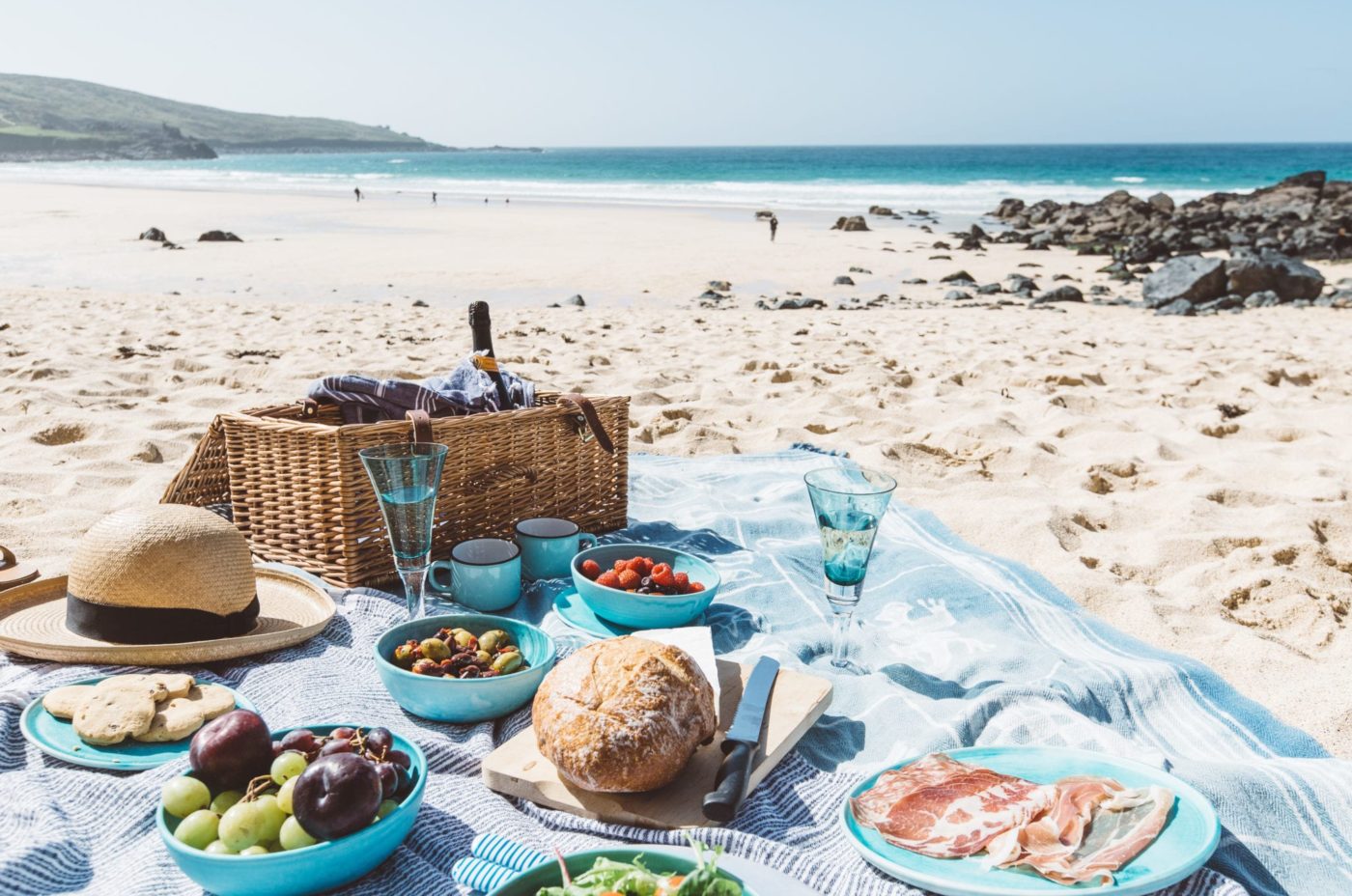 A picnic spread laid out on an empty sandy beach