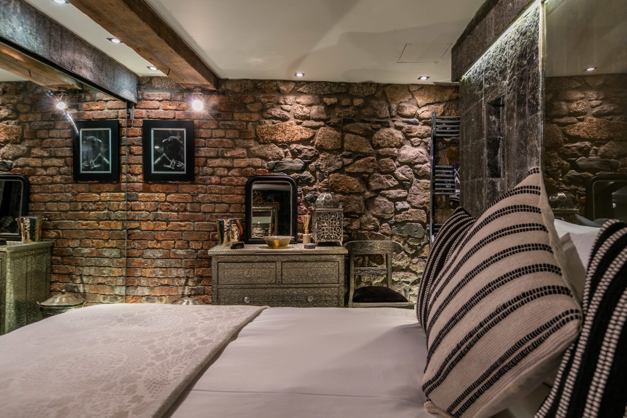 Exposed stone and a sumptuous super king size bed in Black Moon
