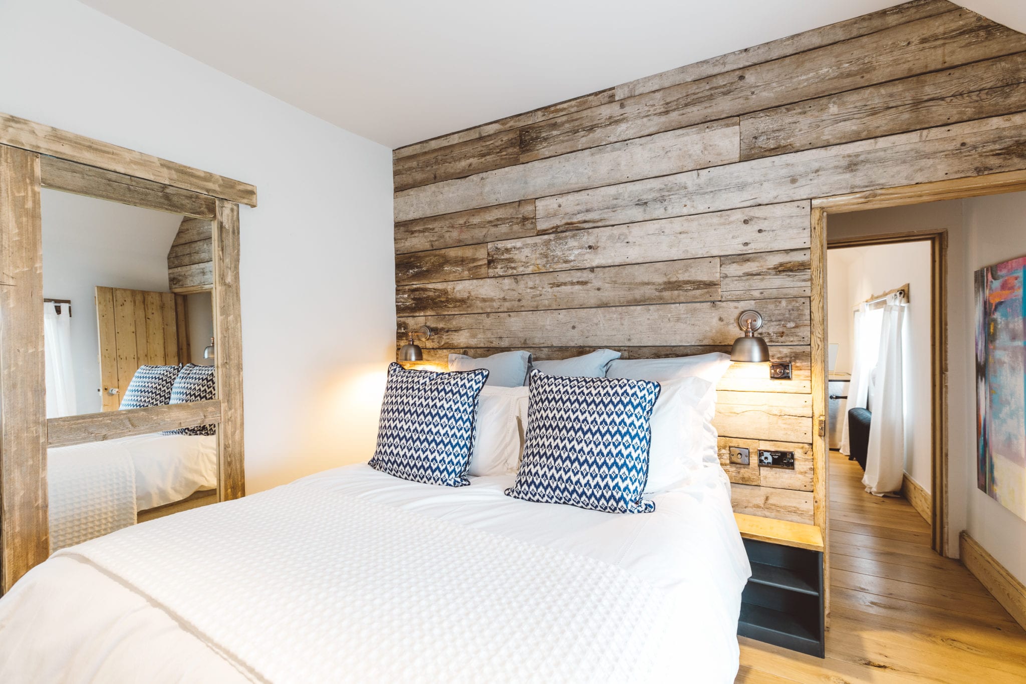 A bedroom with a double bed and exposed wood cladding