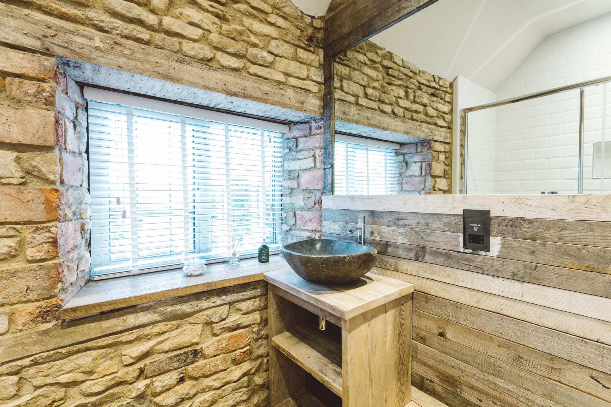 A bathroom with exposed stone walls