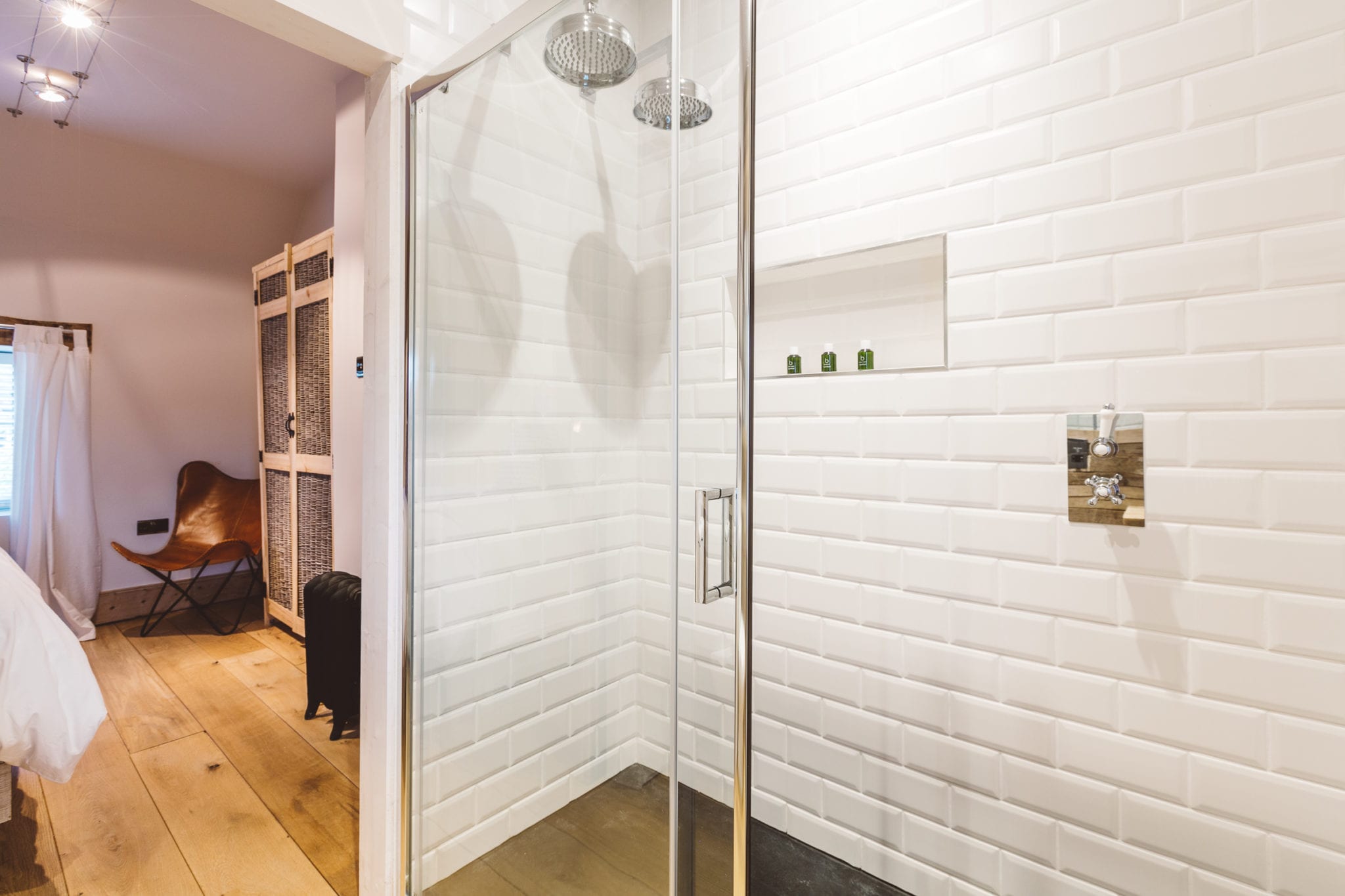 An en-suite shower with white tiling