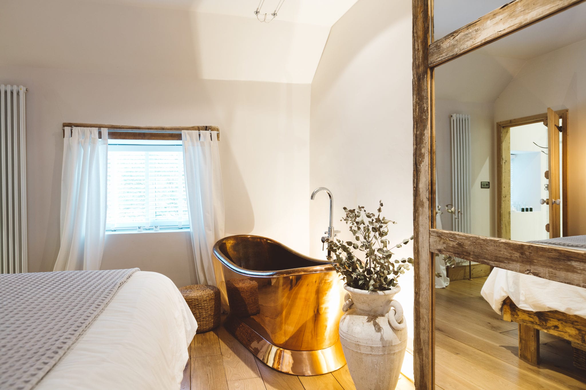 A copper roll top bath tub in Ivy Cottage's master bedroom
