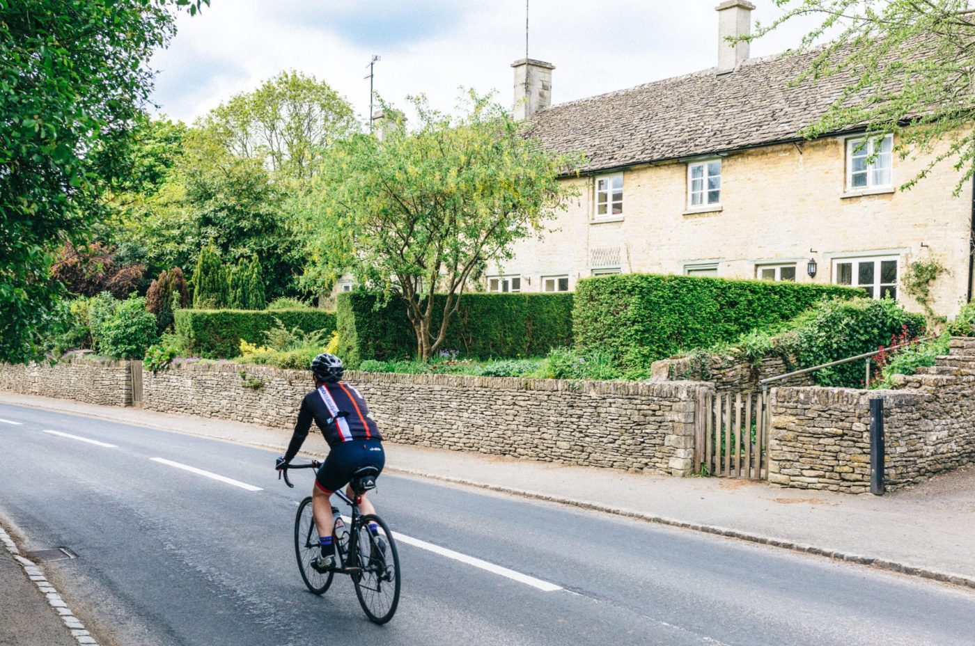 A man cycling through a country village