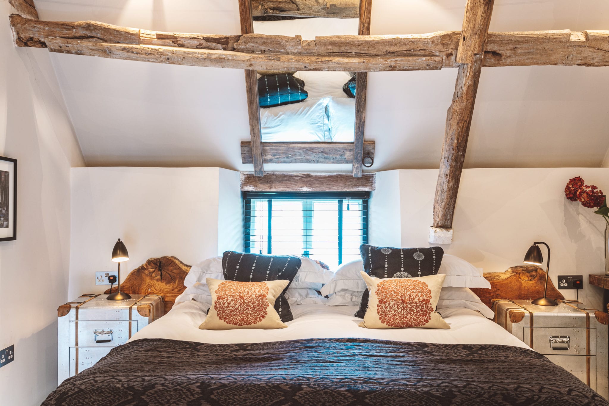A large bed underneath striking exposed wooden beams