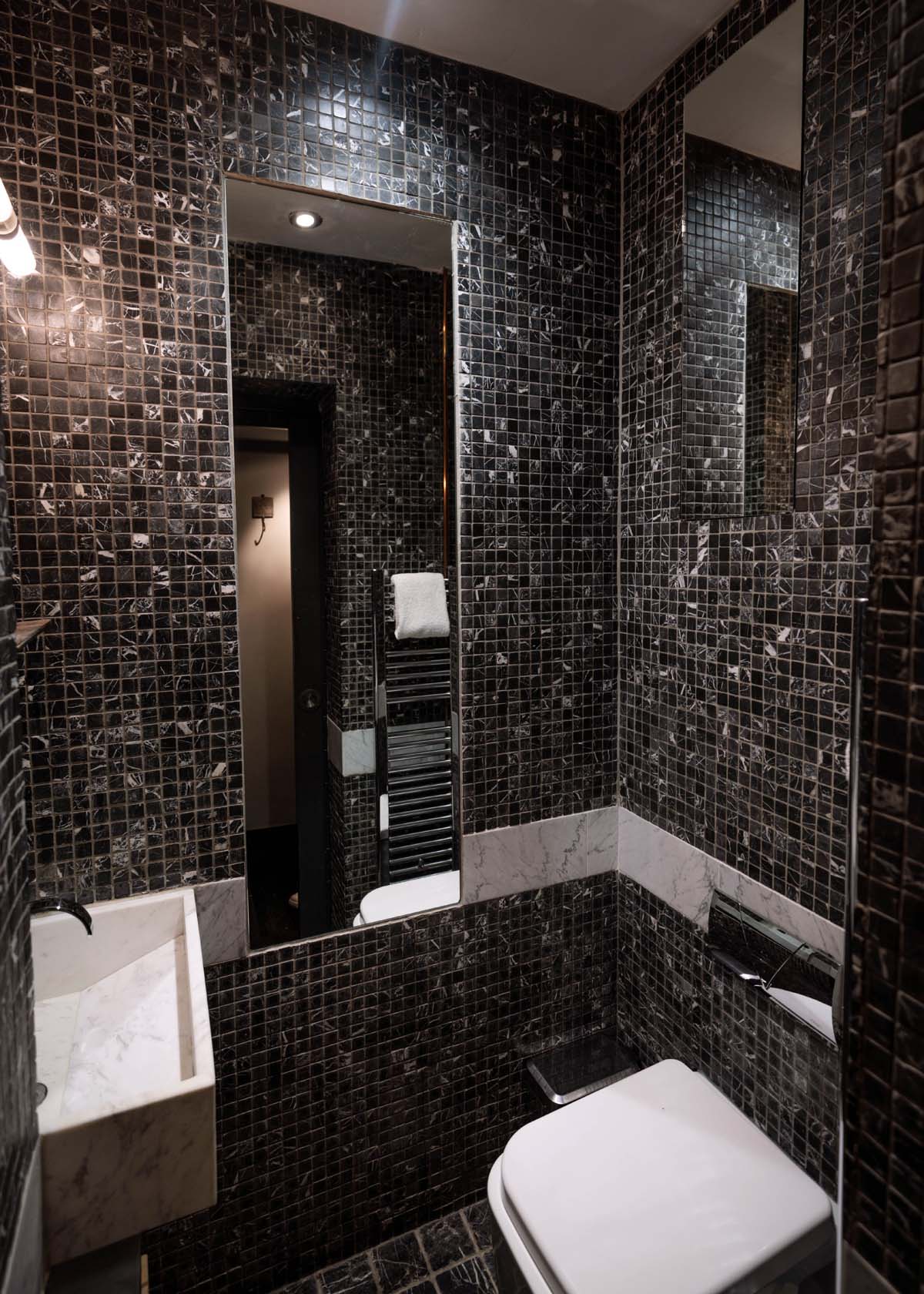A loo with black mosaic tiles