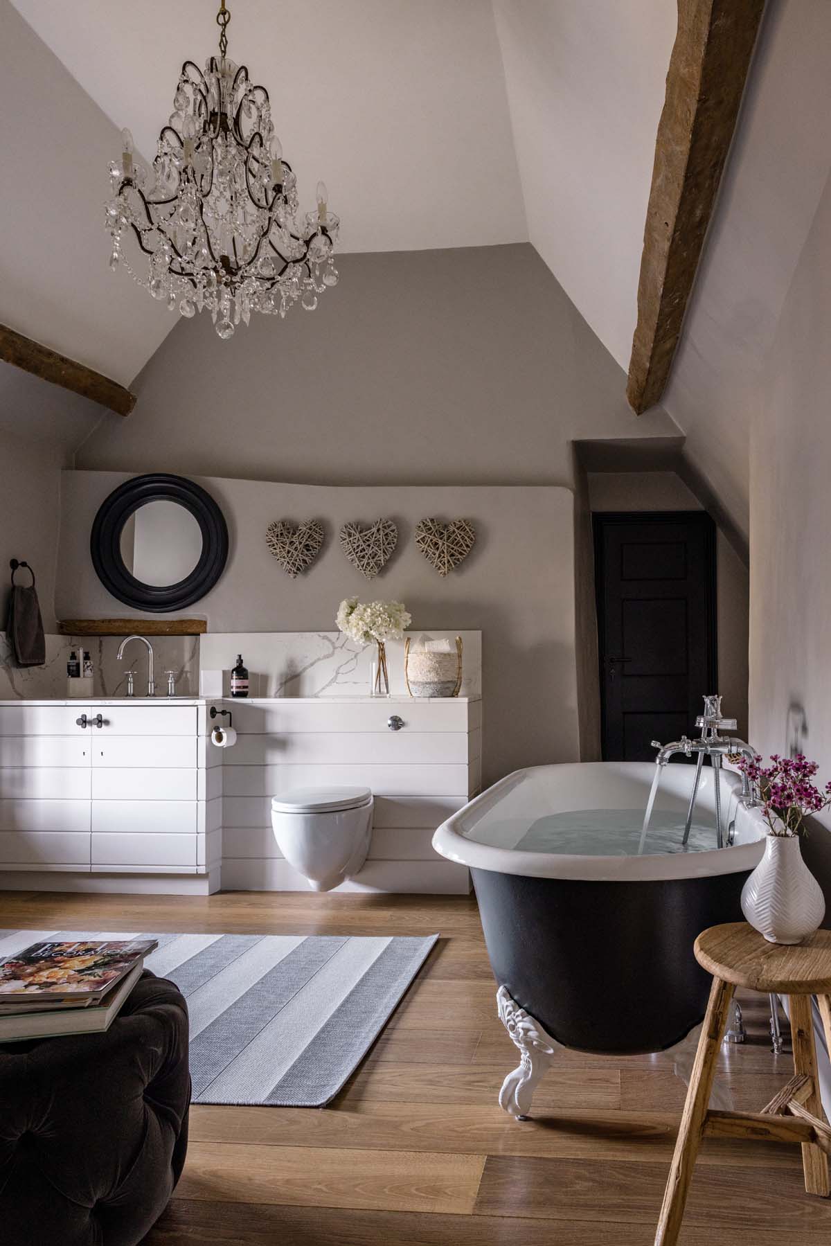 Bathroom with a chandelier and grey rolltop bathtub