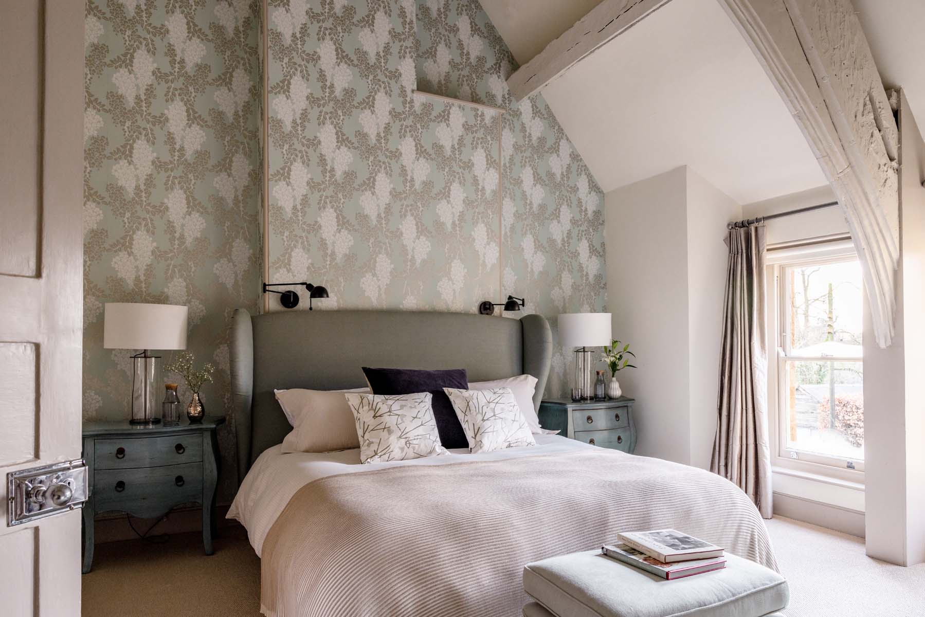Bedroom with high ceilings and patterned wallpaper