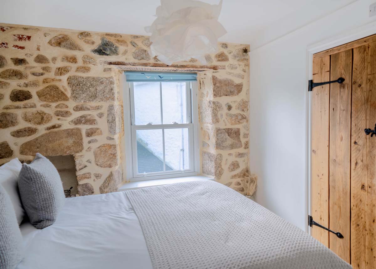 Bedroom with wooden doors and exposed stone walls