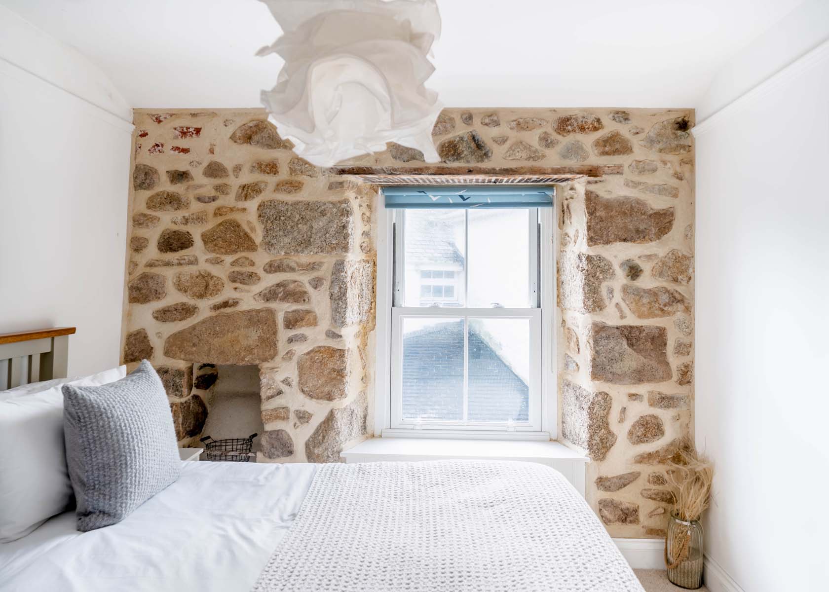 Simple modern bedroom with exposed stone walls