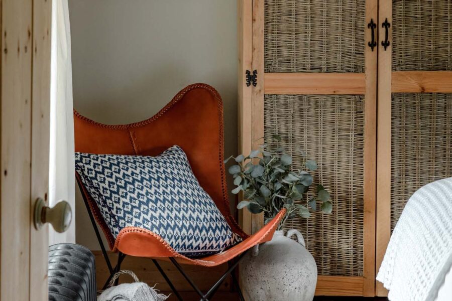 Leather chair with blue patterned cushion and rattan wardrobe