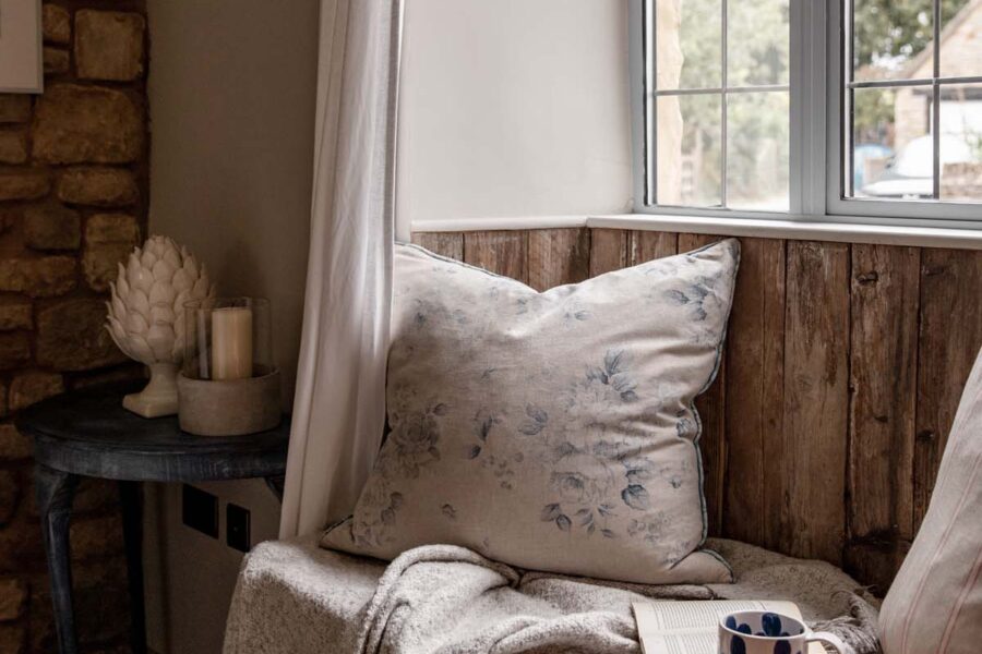cosy windowsill seat with floral cushion, book and mug