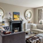 Luxurious interior designed living room with high end furnishings, mirrors and artwork