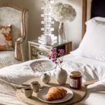 Breakfast tray with croissants and jam in bed