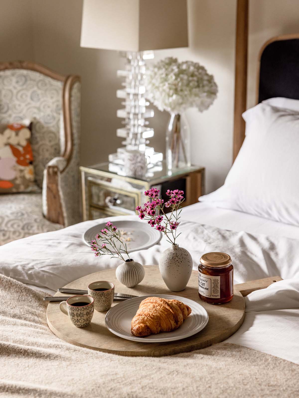 Breakfast tray with croissants and jam in bed