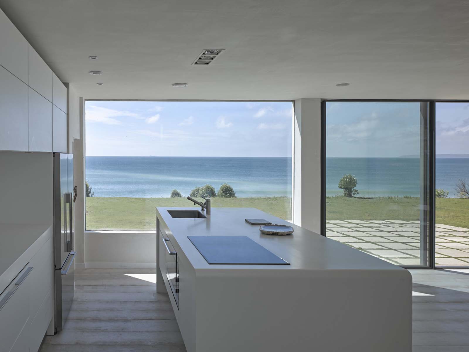 A sleek open plan minimal kitchen with sea views