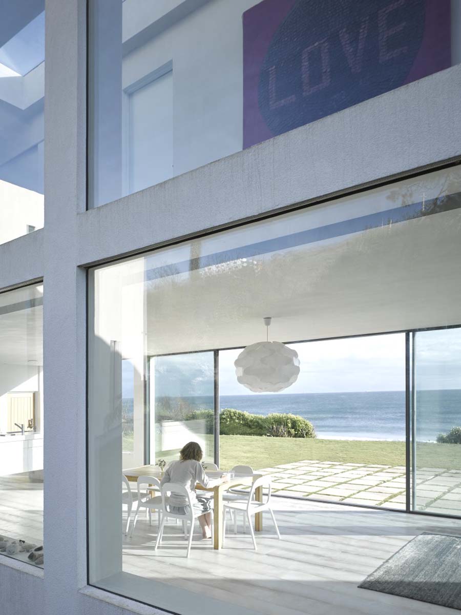 Modern house with large glass windows and views of the sea