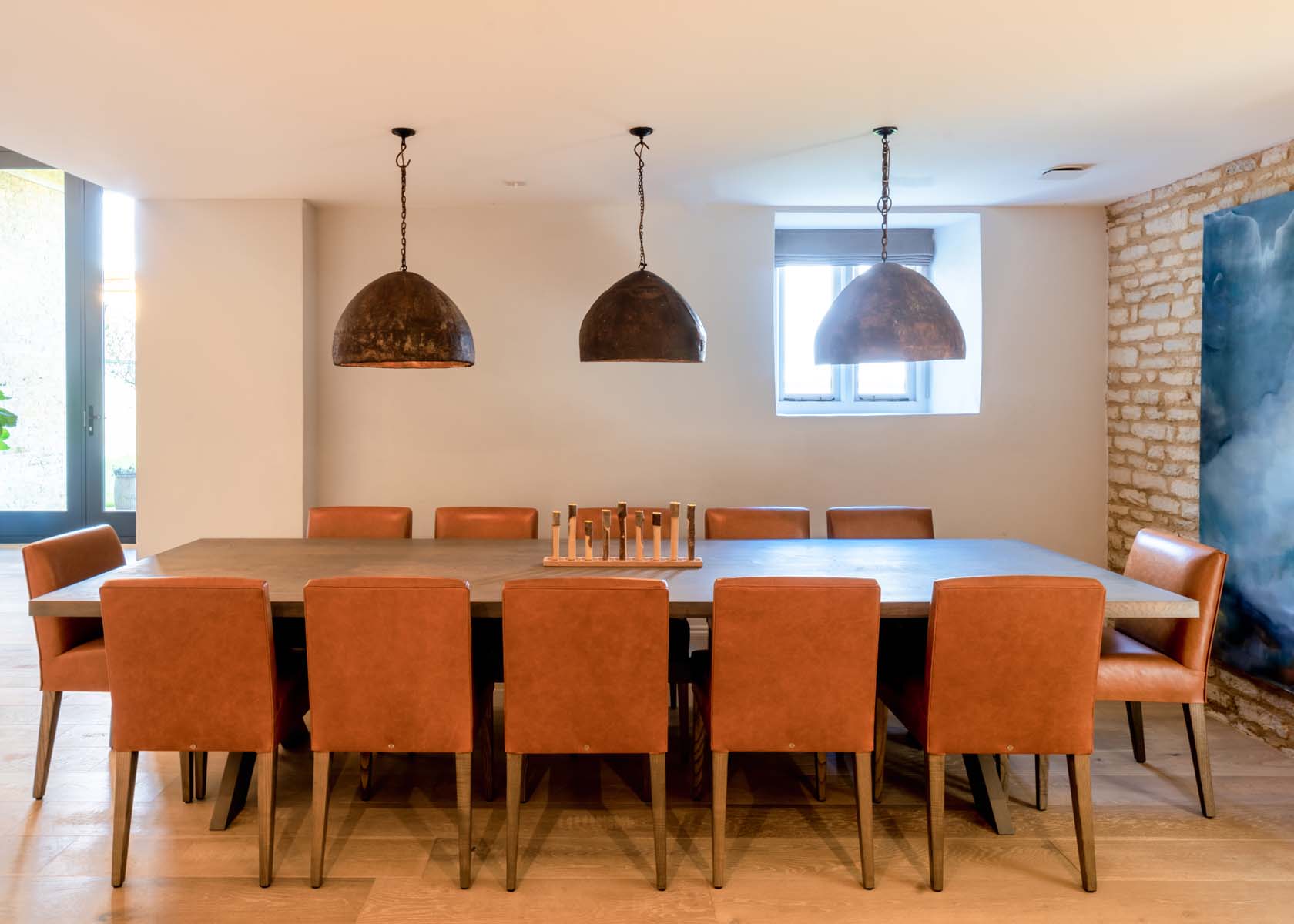 A minimal dining table with tan leather chairs