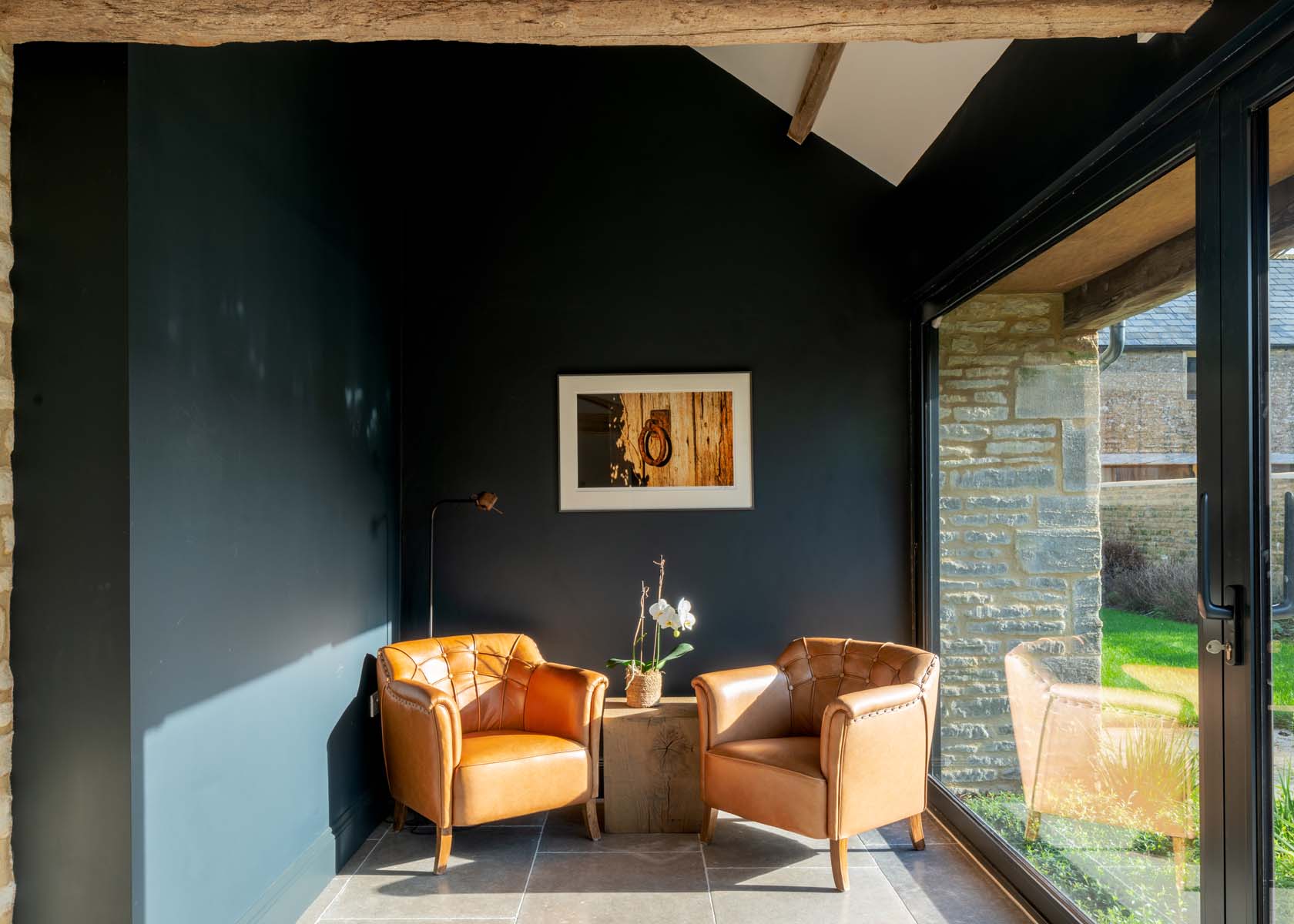 Room with dark green painted walls and tan leather chairs