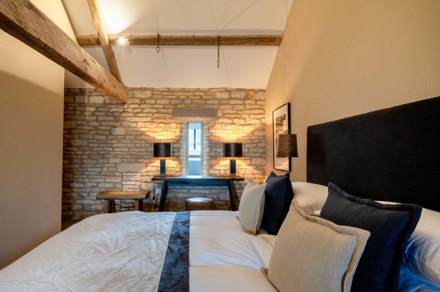 Bedroom with exposed stone walls and exposed wooden beams