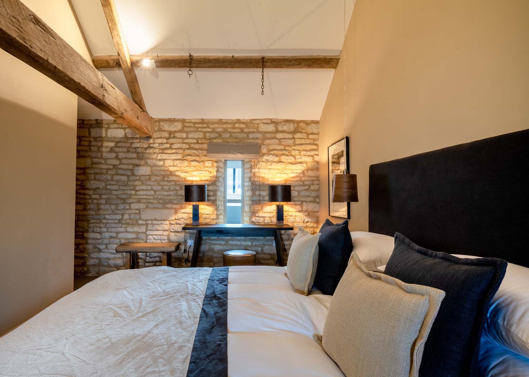 Bedroom with exposed stone walls and exposed wooden beams
