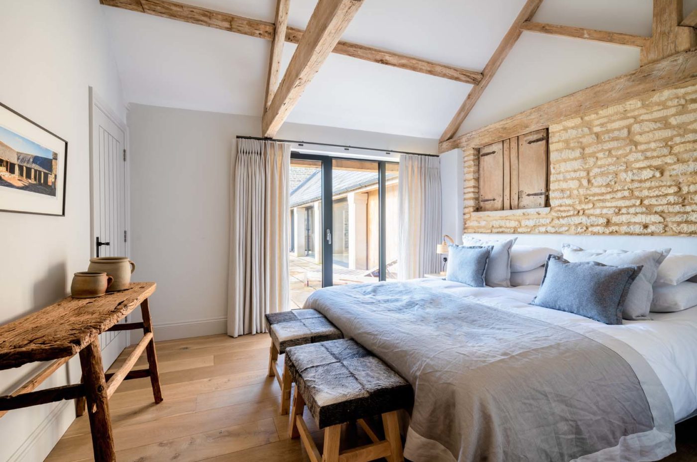 Large bright bedroom with french doors and exposed wooden beams