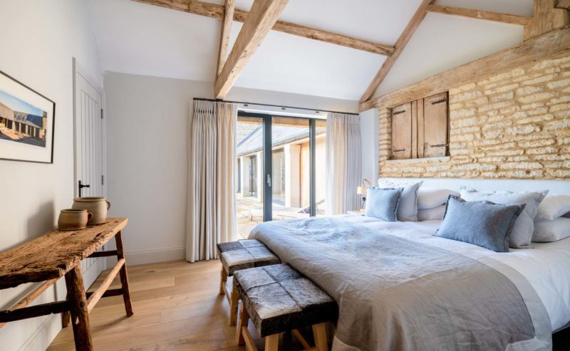 Large bright bedroom with french doors and exposed wooden beams