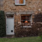 Country house autumnal exterior with warm lights on inside