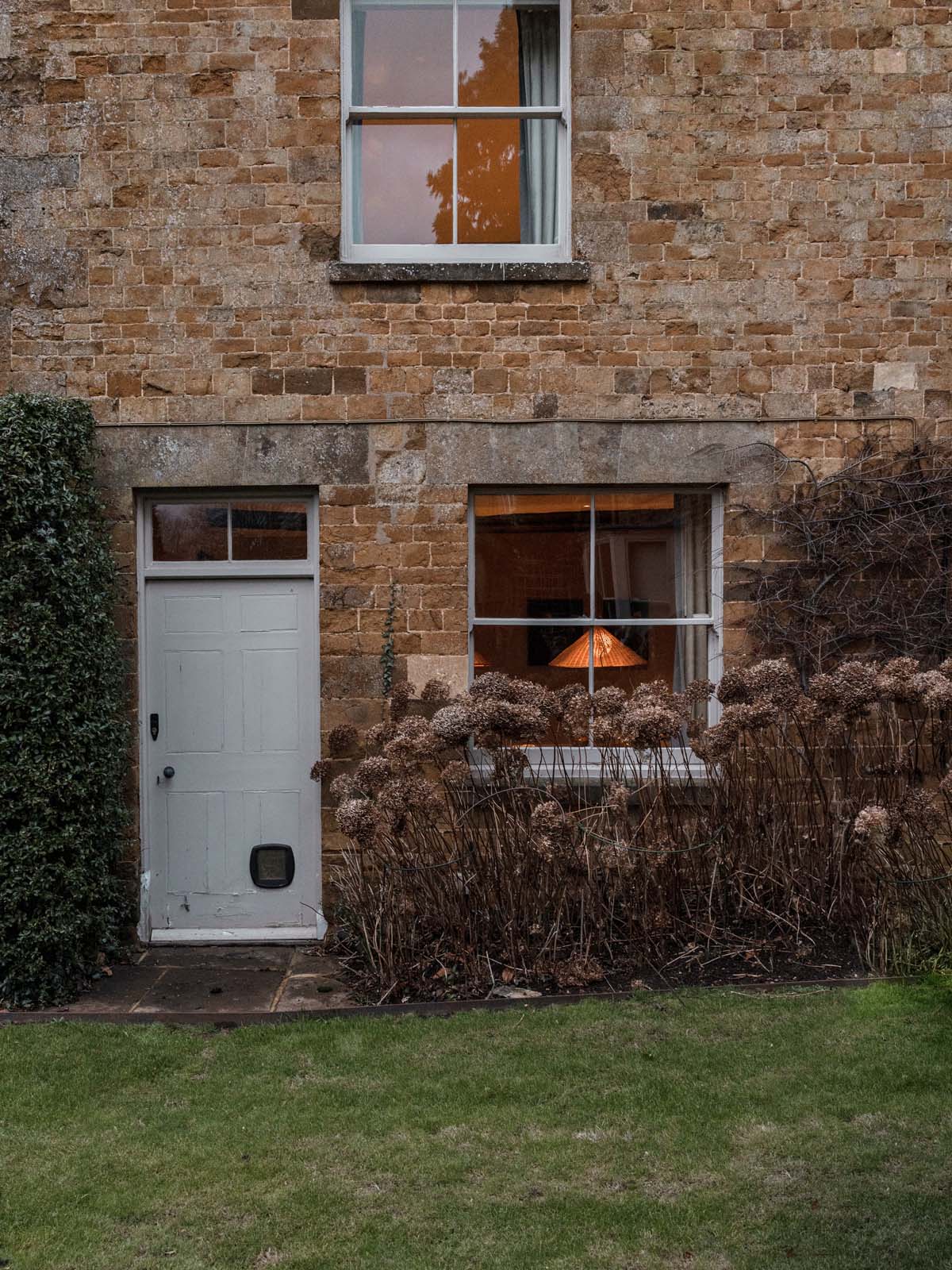 Country house autumnal exterior with warm lights on inside