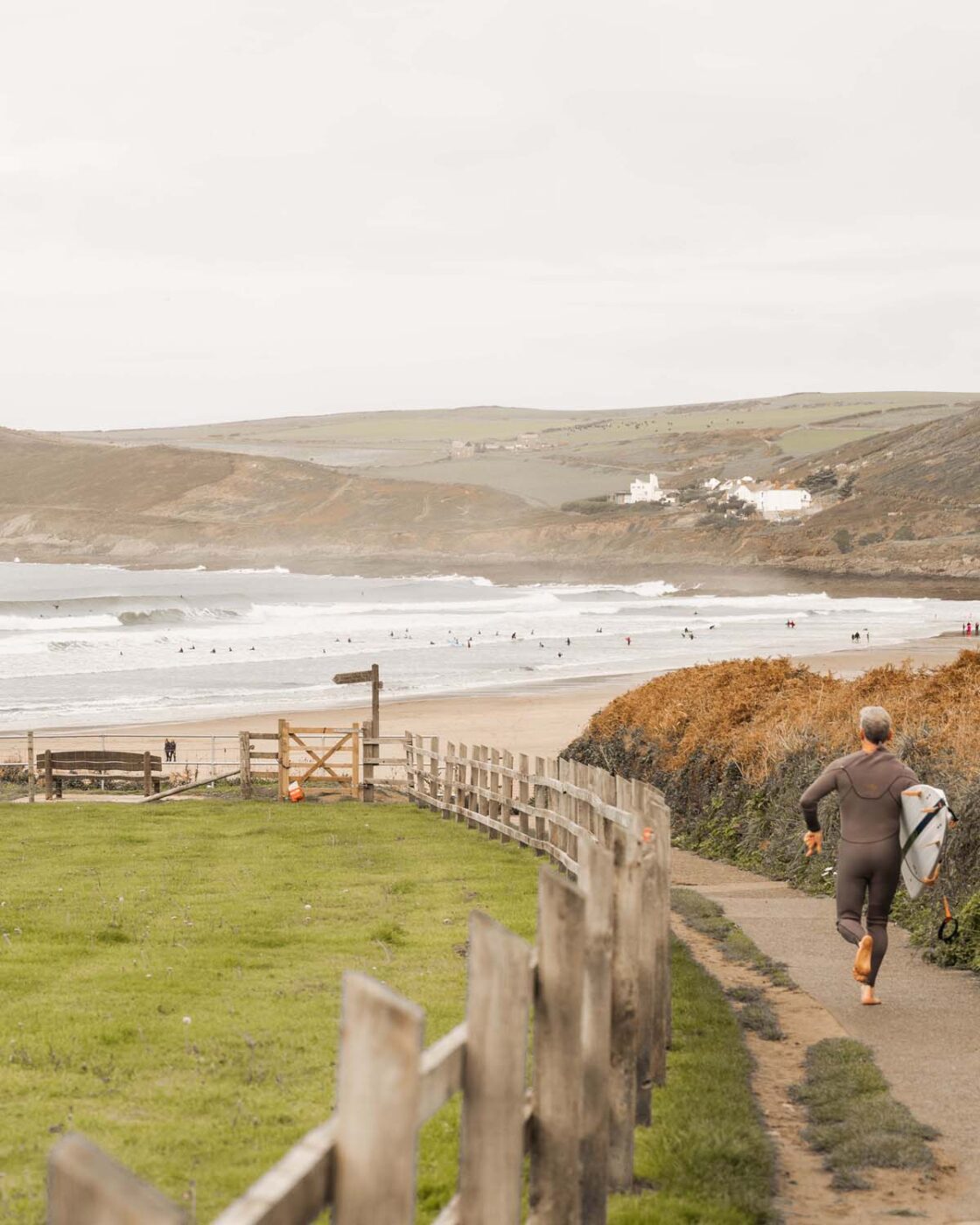 Man running with surfboard onto the beach