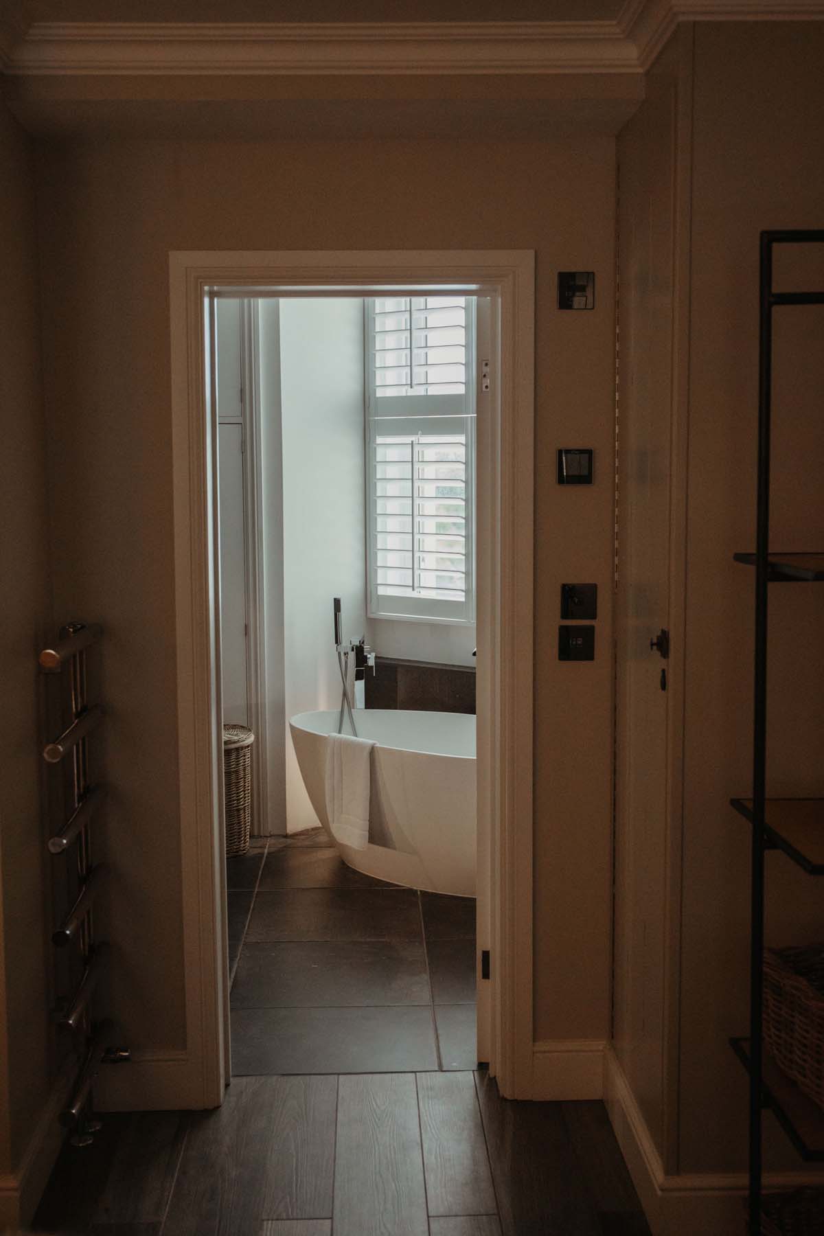 Doorway to bathroom with modern white bath