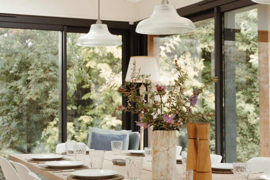Large dining table laid with glasses, plates and flowers