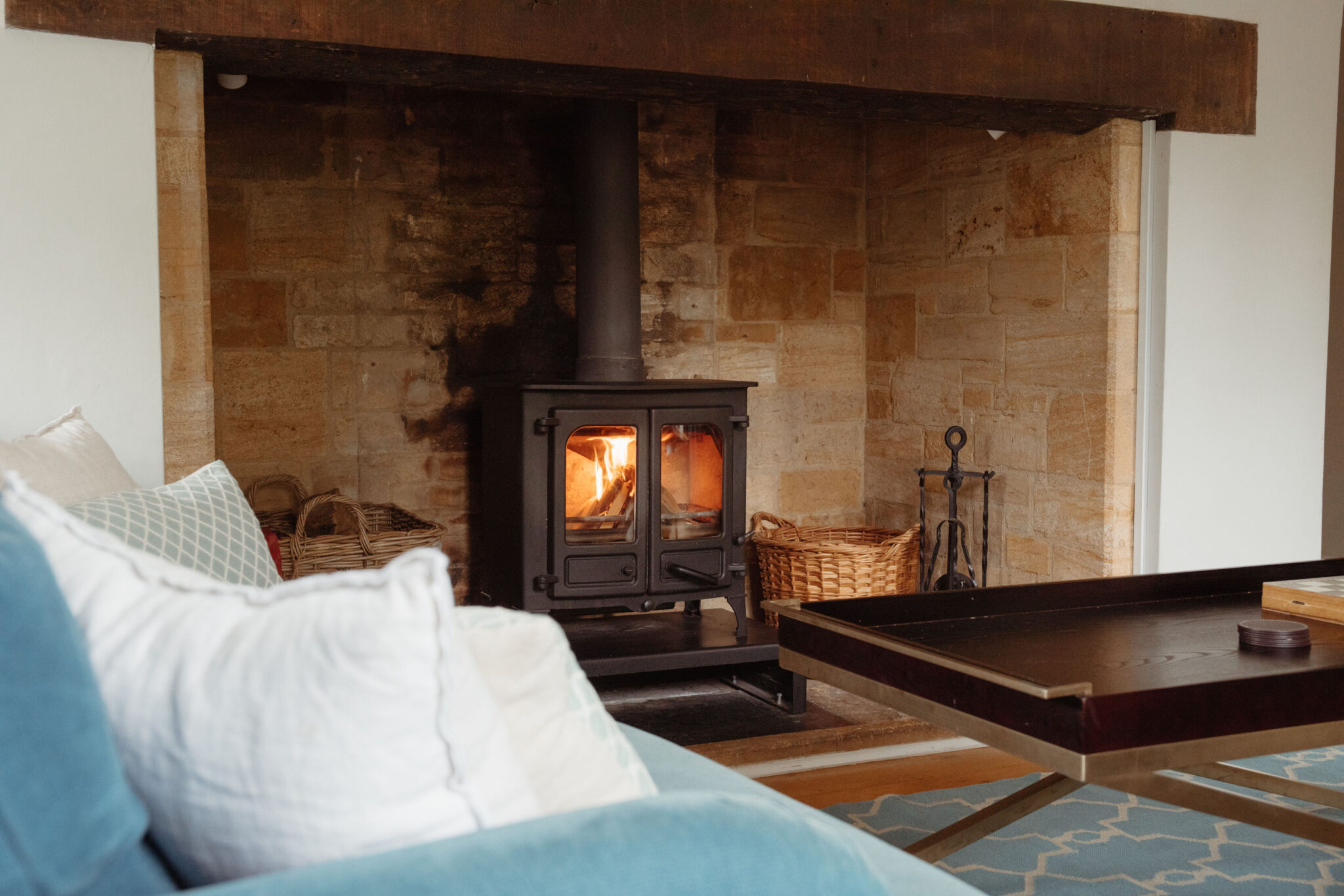 Sitting room with wood burning stove in a large old fireplace