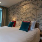 Large en-suite bedroom with printed wallpaper