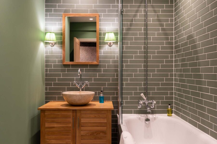 Bathroom with green tiles and shower/bath