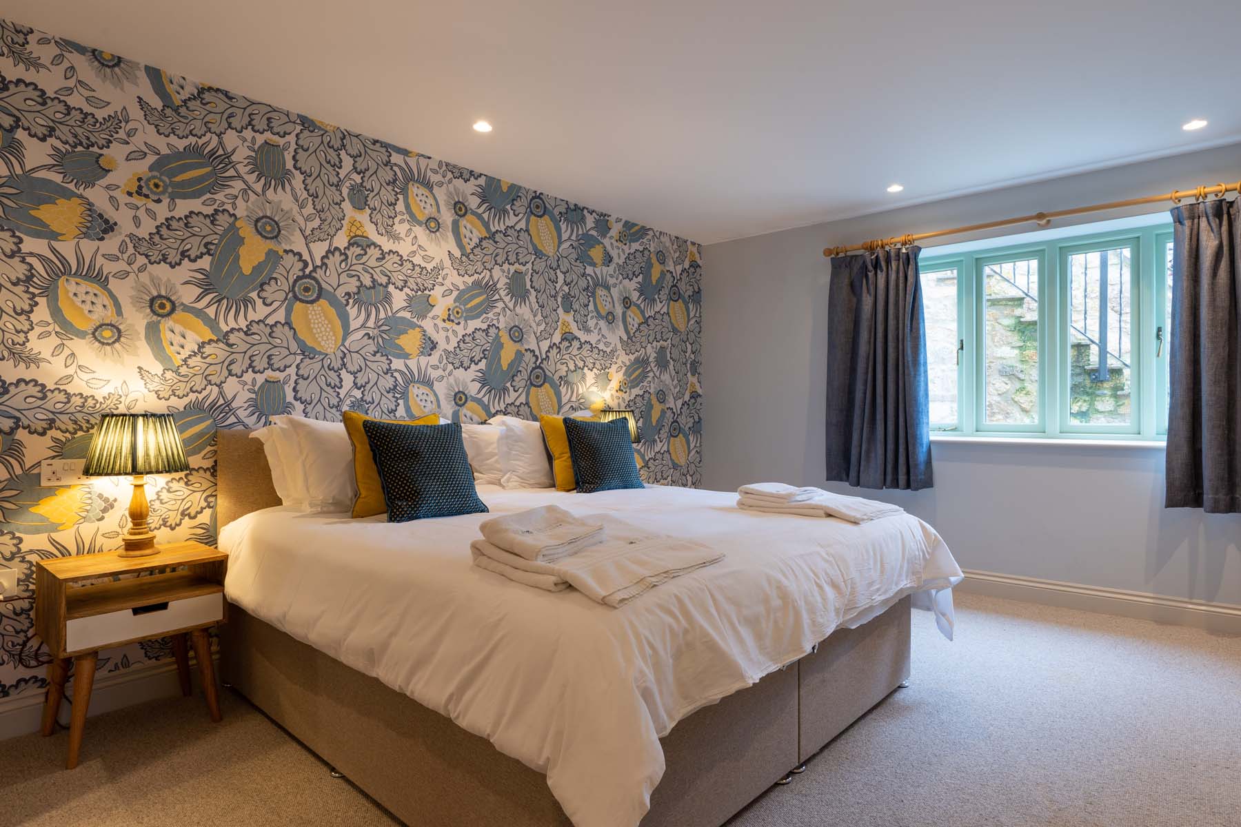 Large bedroom with blue flowery wallpaper