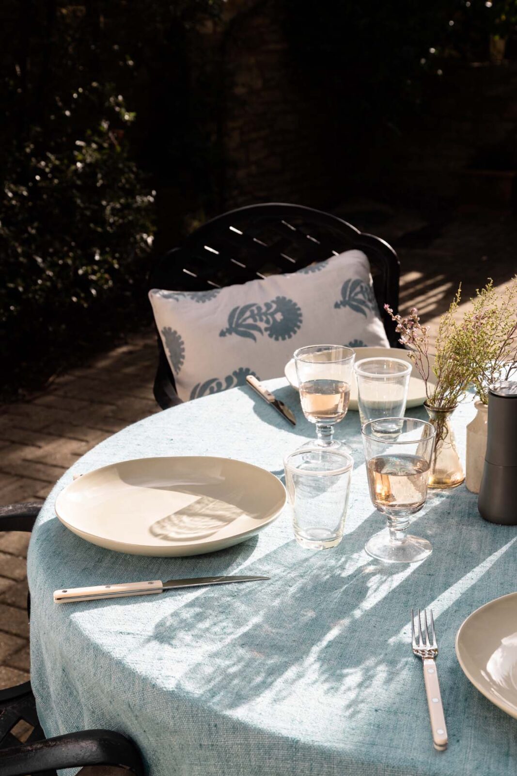 A dressed garden table with rose wine