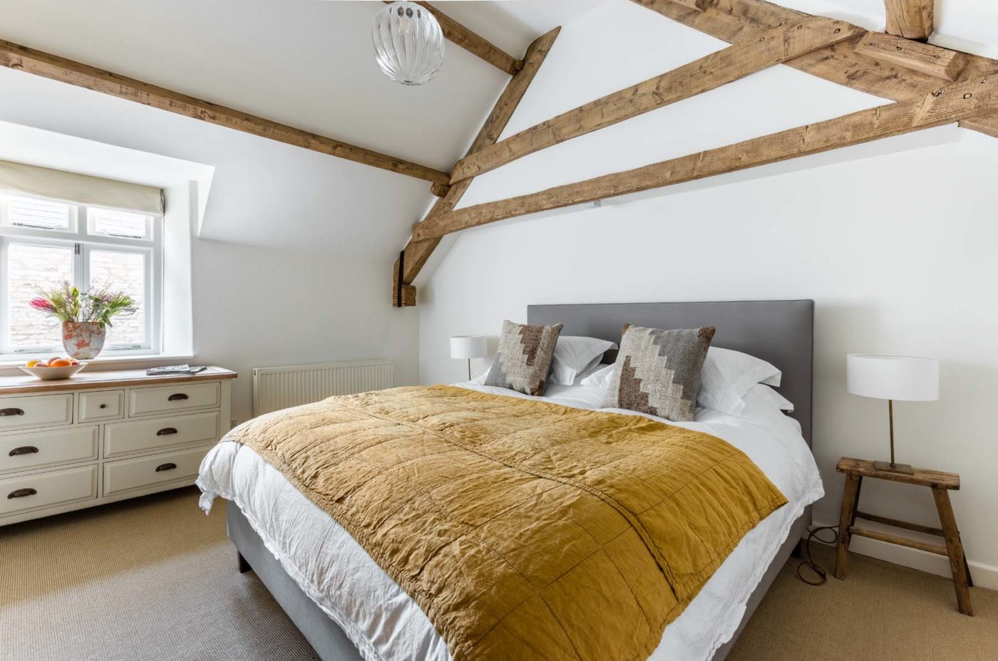 A minimal modern country bedroom with wooden beams