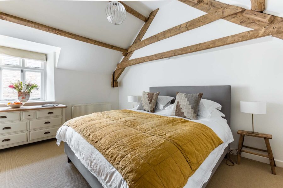 A minimal modern country bedroom with wooden beams