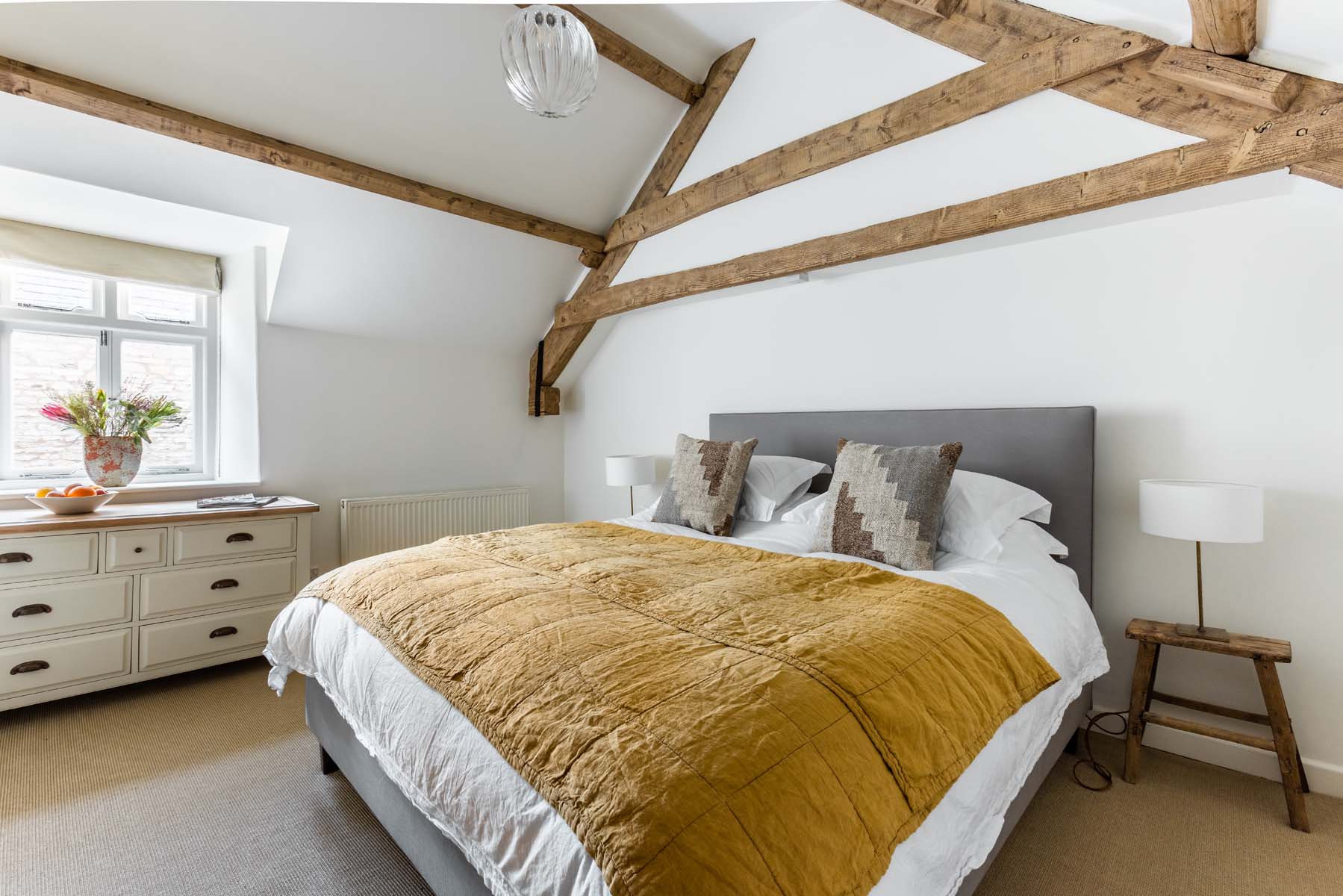 Cottage bedroom with wooden beams and white walls