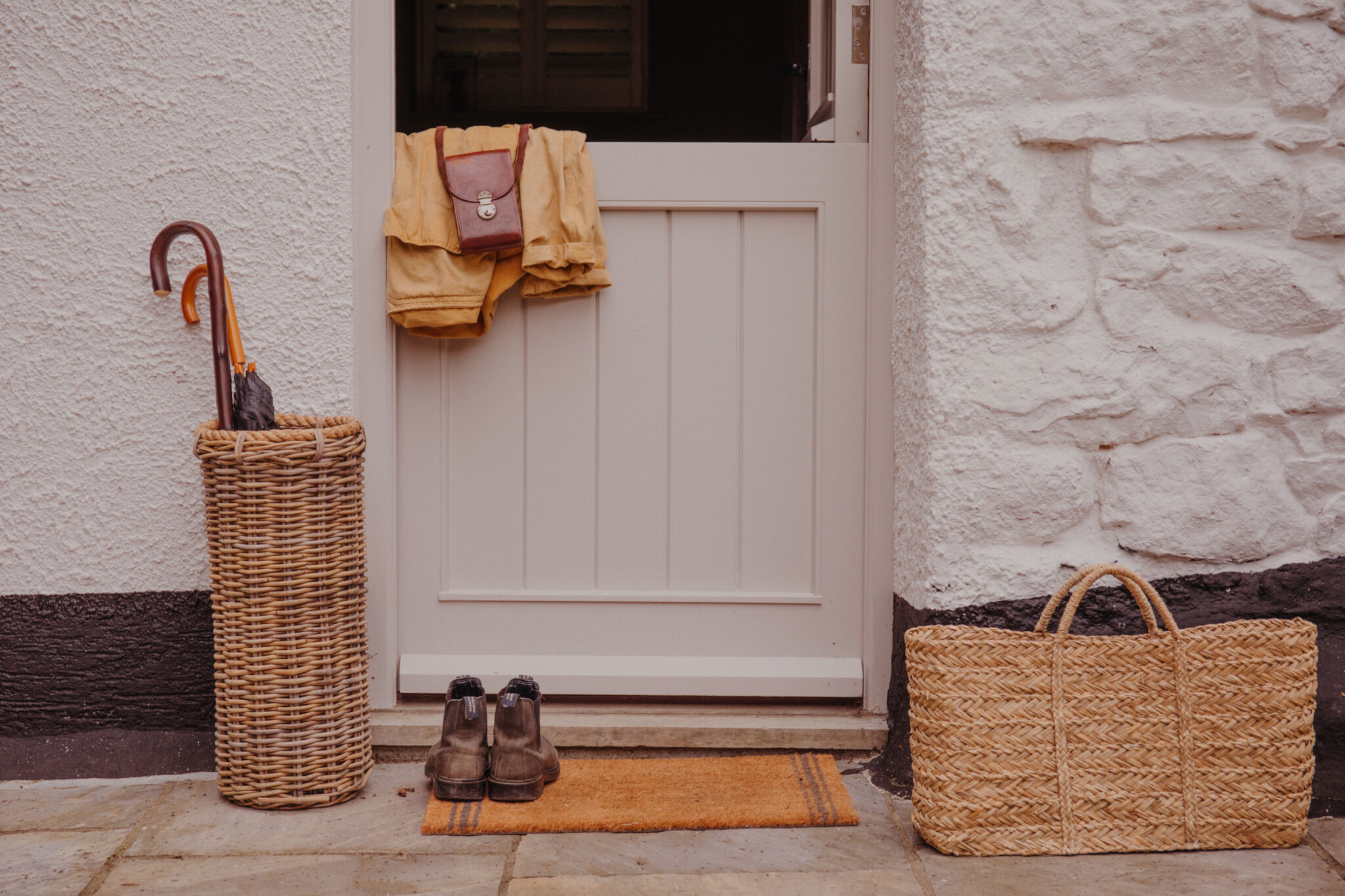 Coats, boots and a basket by a cottage stable door