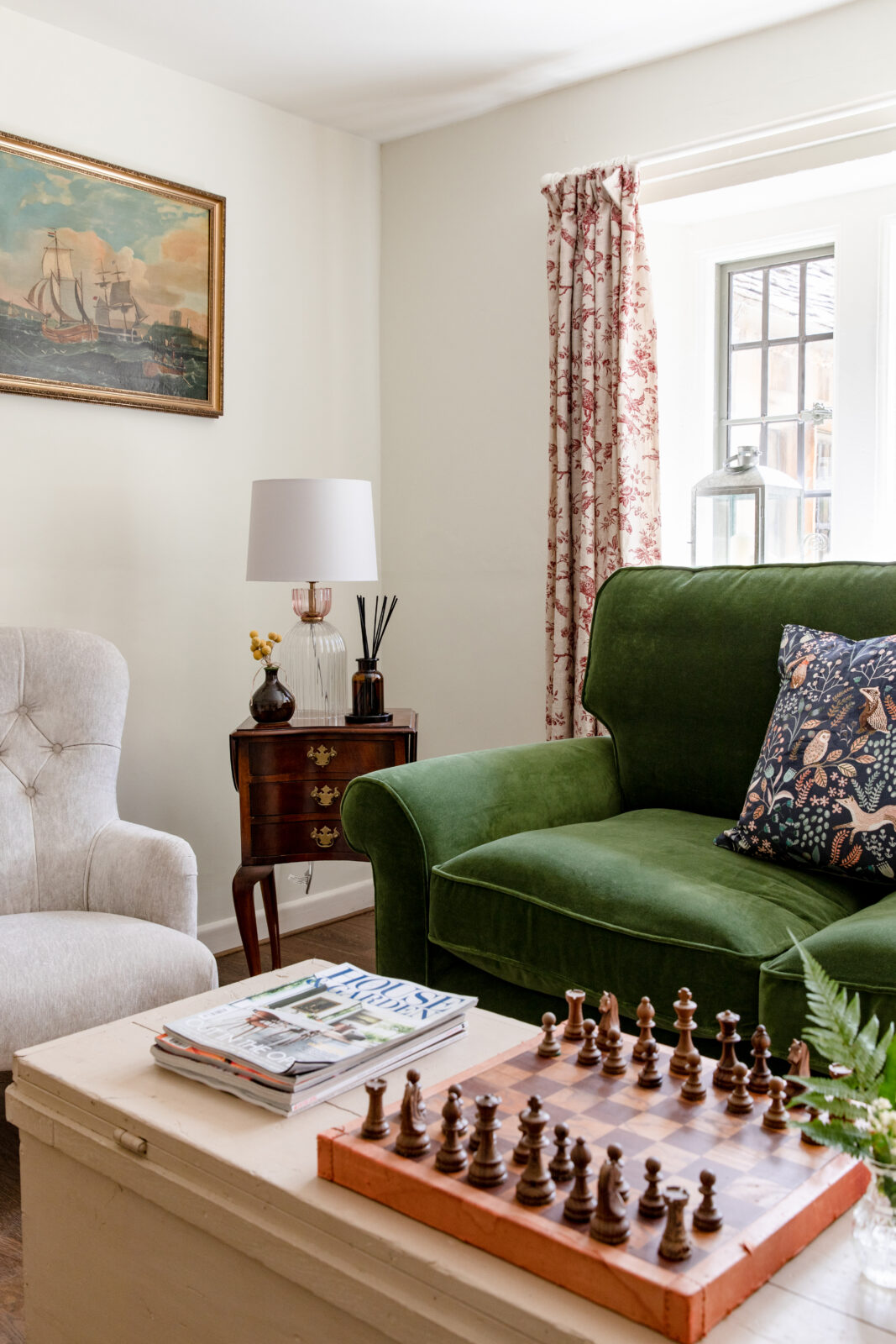 Corner of green velvet sofa with chessboard