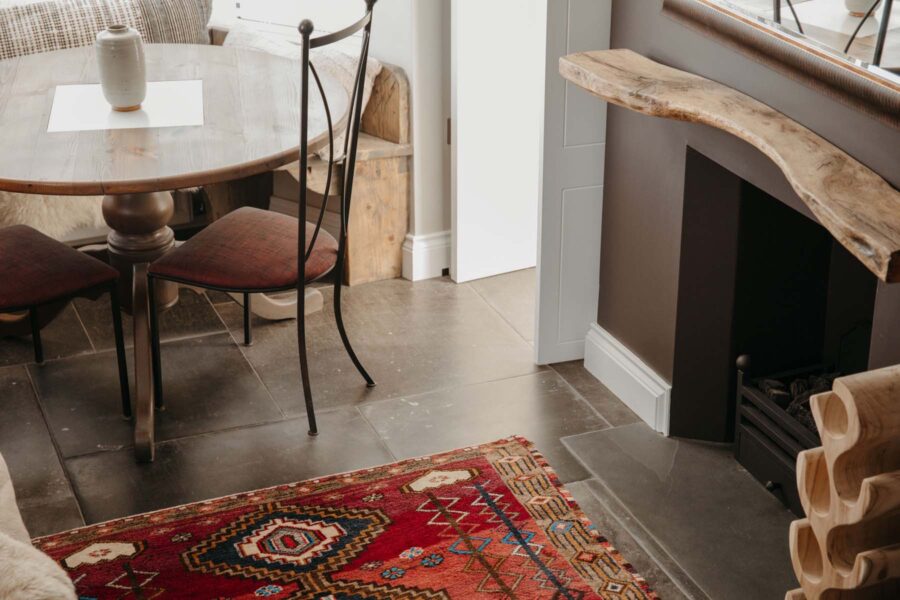 Afghan rug by a fireplace