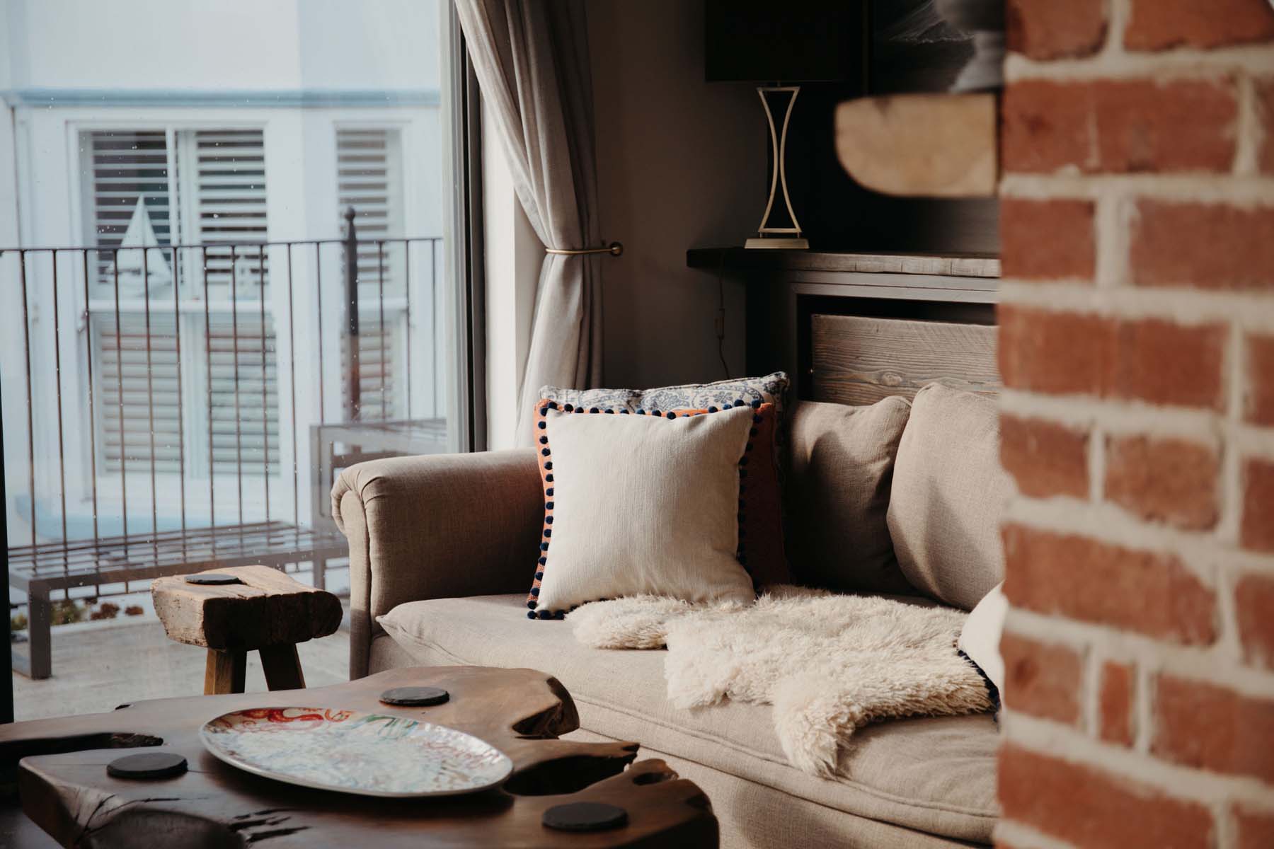 Cosy indoor seating beside a window with a balcony