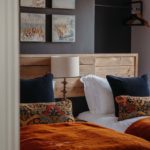 Twin bedroom with wood cladding and velvet throws
