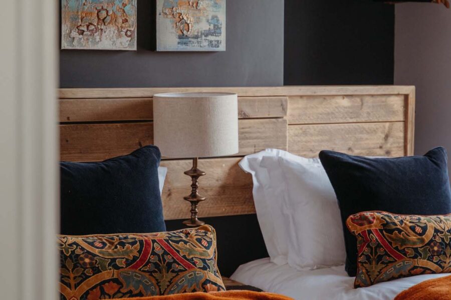 Twin bedroom with wood cladding and velvet throws
