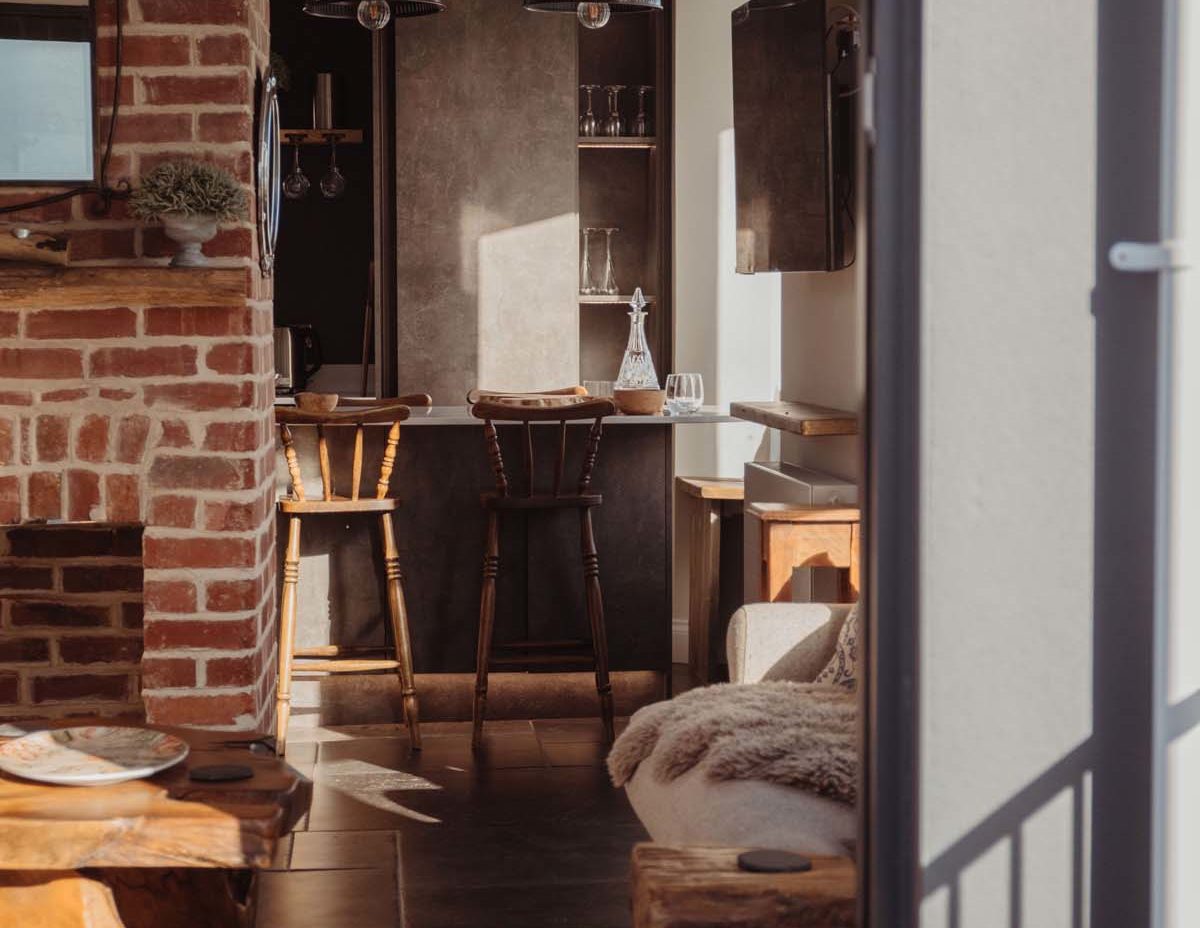 Open plan room with exposed brick wall and scant style furniture