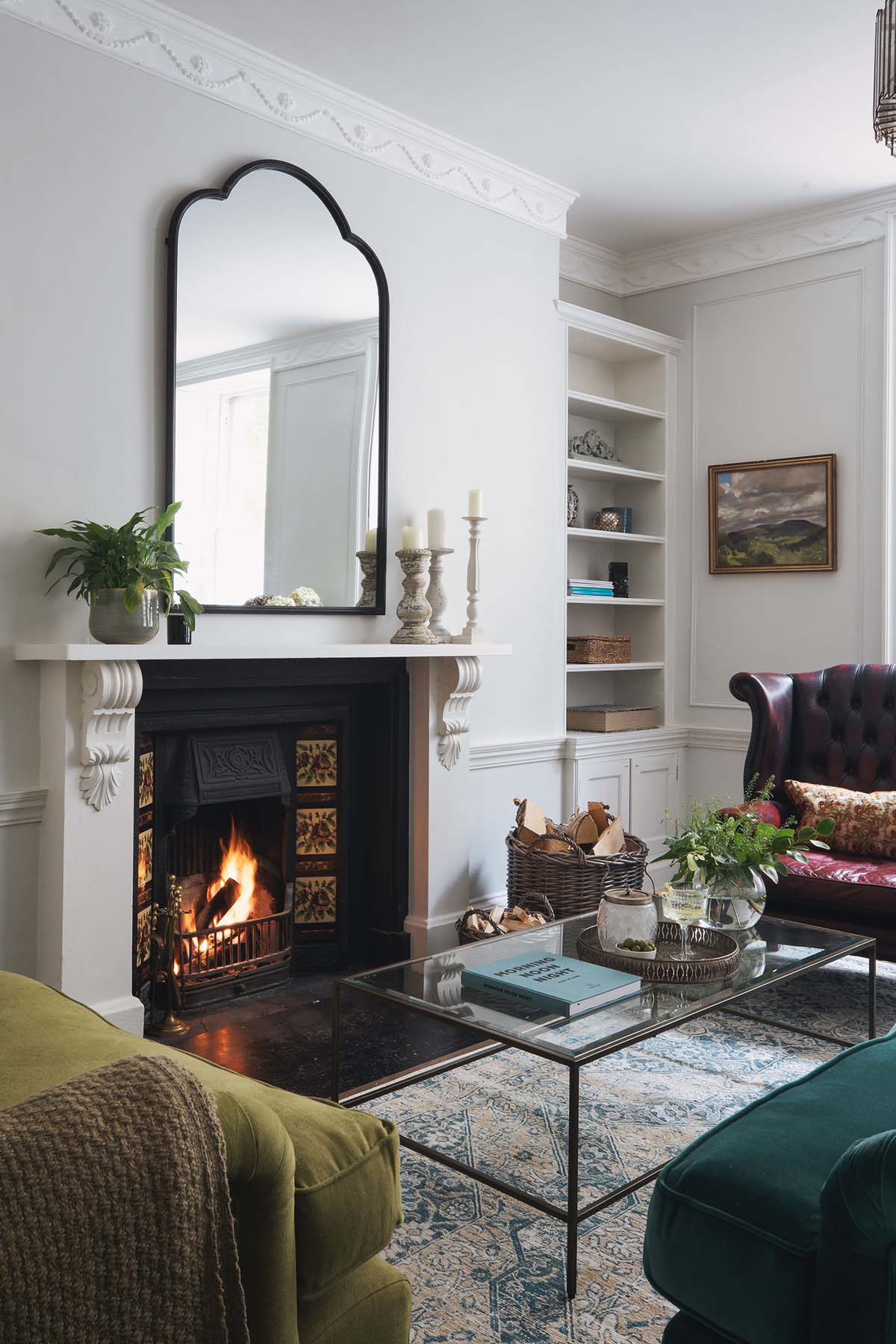open fireplace with overhead mirror and shelves