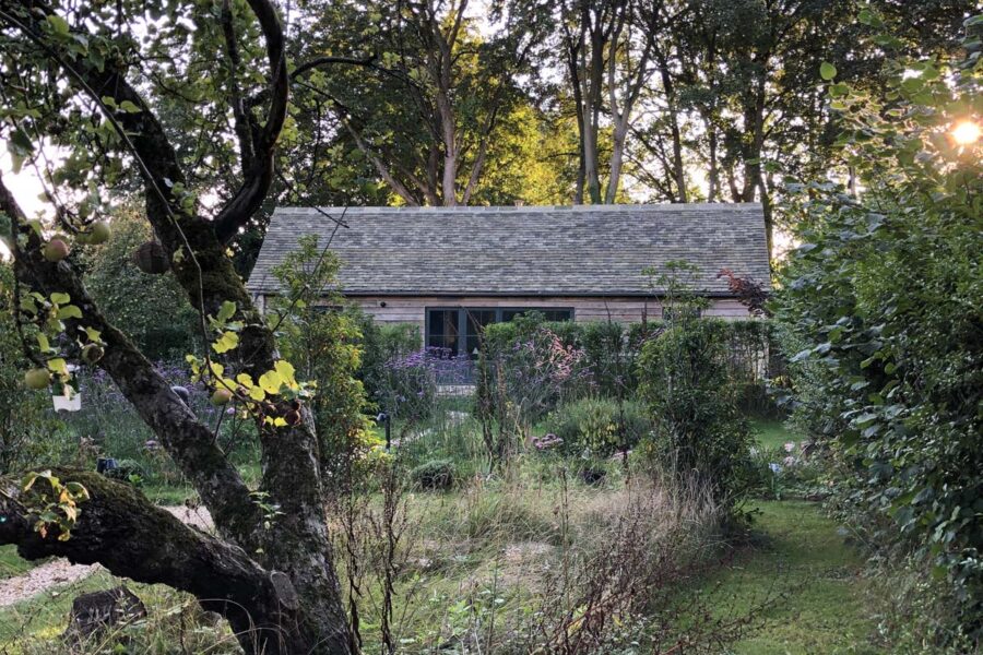 Cottage exterior surrounded by trees and garden