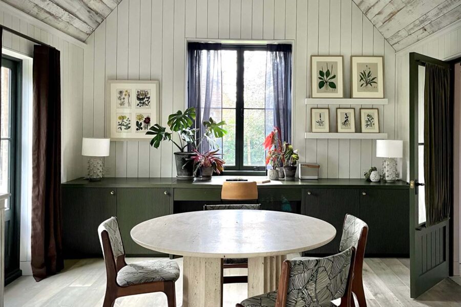 Circular dining table with chairs and botanical prints on walls