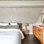 bedroom with sloping loft ceiling and rattan bedside lamps